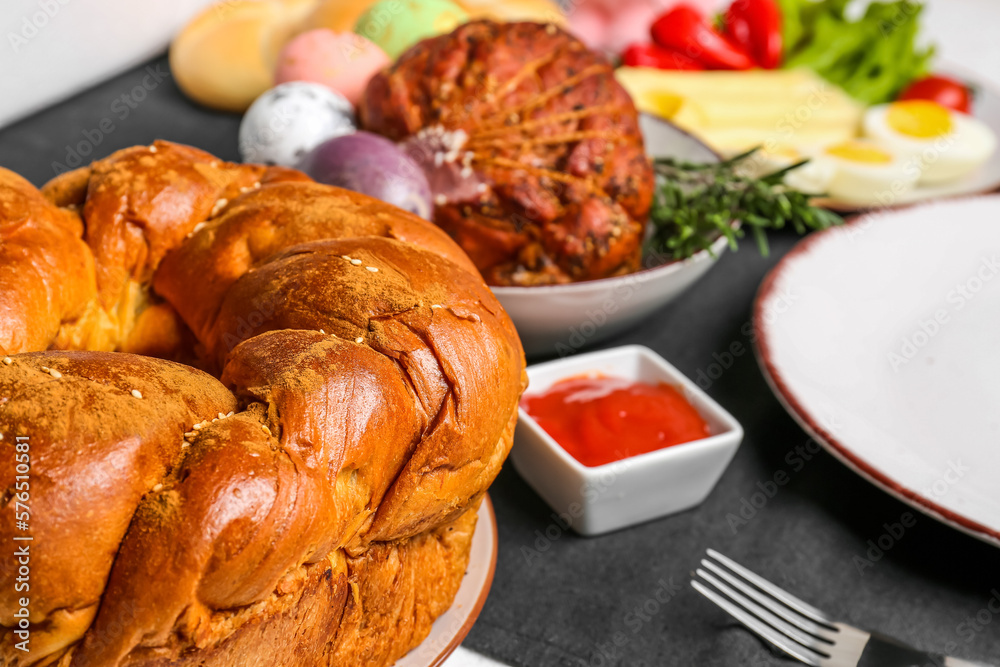 Tasty Easter wreath bread and dishes for dinner on table, closeup Tasty Easter wreath bread and dishes for dinner on table, closeup