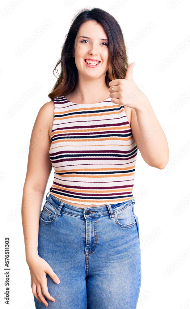 Fototapeta premium Beautiful young brunette woman wearing casual clothes smiling happy and positive, thumb up doing excellent and approval sign