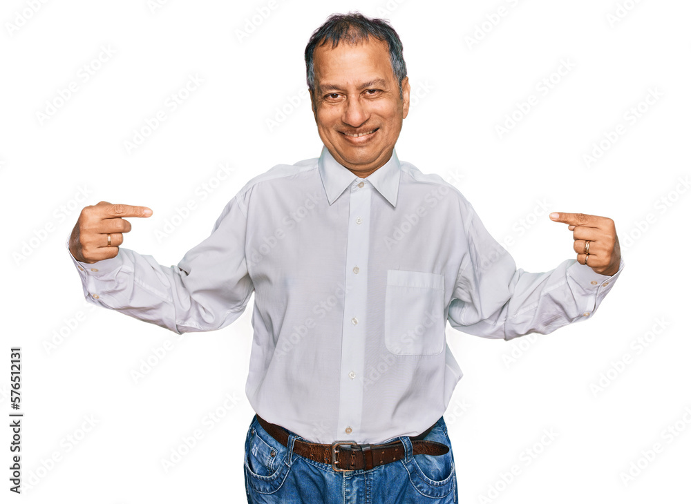 Middle age indian man wearing casual white shirt looking confident with smile on face, pointing oneself with fingers proud and happy.