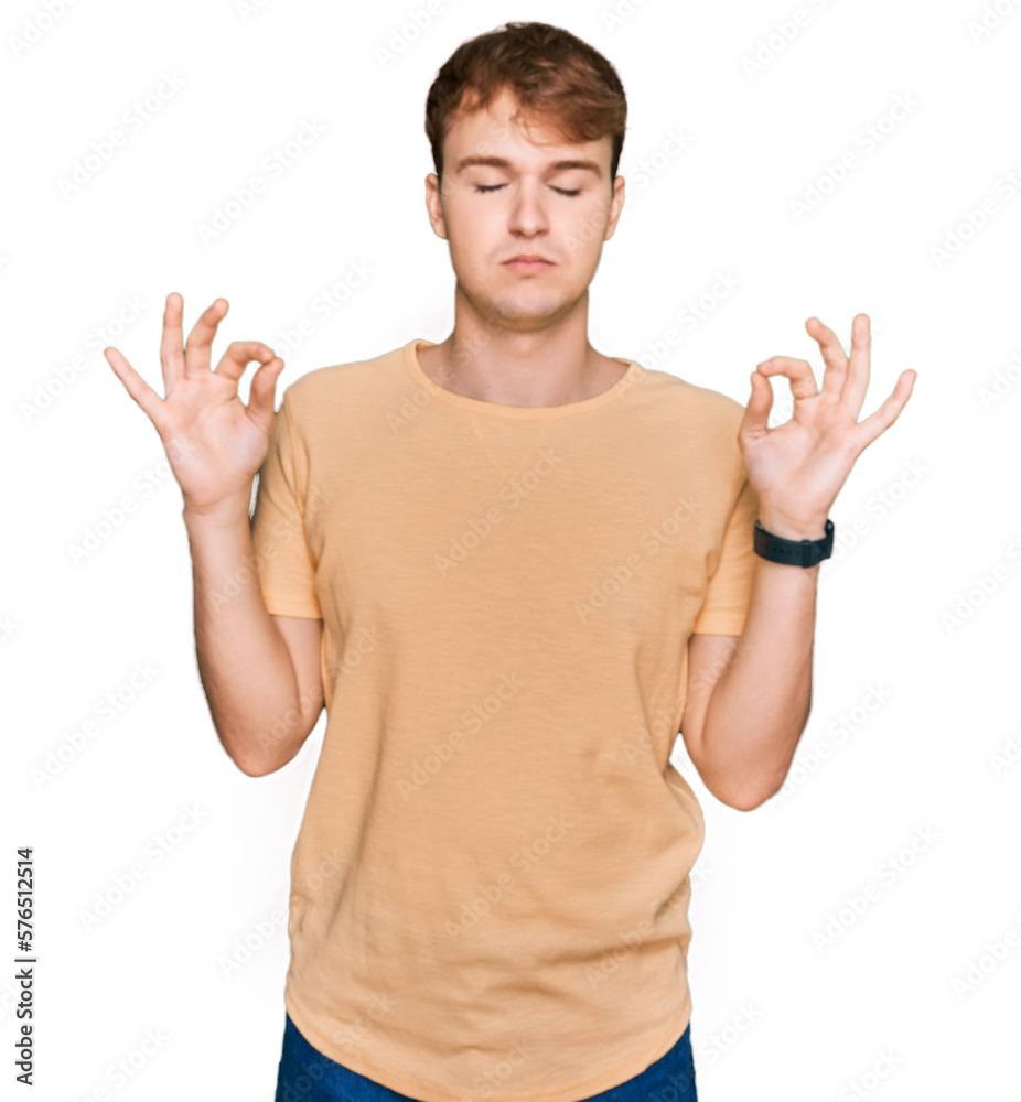 Young caucasian man wearing casual clothes relaxed and smiling with eyes closed doing meditation gesture with fingers. yoga concept. Young caucasian man wearing casual clothes relaxed and smiling with eyes closed doing meditation gesture with fingers. yoga concept.