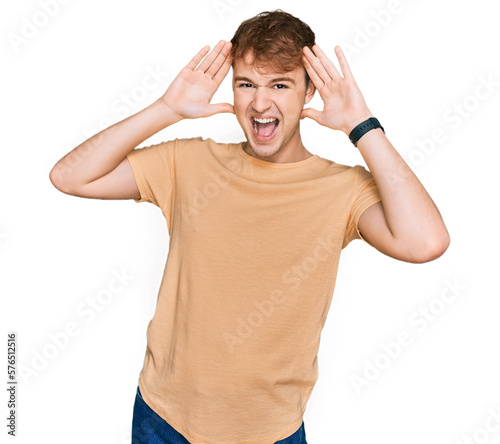 Young caucasian man wearing casual clothes smiling cheerful playing peek a boo with hands showing face. surprised and exited © Krakenimages.com