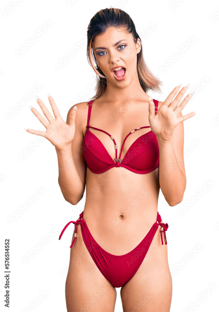 Young beautiful woman wearing bikini afraid and terrified with fear expression stop gesture with hands, shouting in shock. panic concept. Young beautiful woman wearing bikini afraid and terrified with fear expression stop gesture with hands, shouting in shock. panic concept.