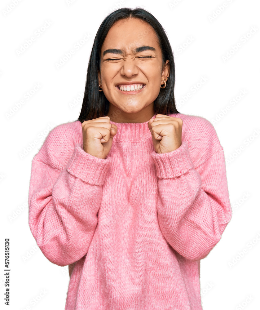 Φωτογραφία Young asian woman wearing casual winter sweater excited for success with arms raised and eyes closed celebrating victory smiling