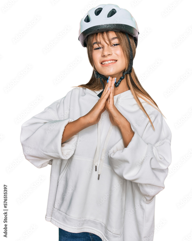 Teenager caucasian girl wearing bike helmet praying with hands together asking for forgiveness smiling confident. Teenager caucasian girl wearing bike helmet praying with hands together asking for forgiveness smiling confident.