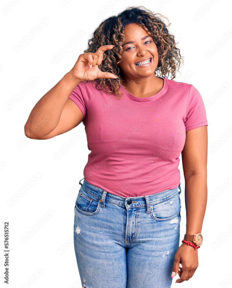 Young african american plus size woman wearing casual clothes smiling and confident gesturing with hand doing small size sign with fingers looking and the camera. measure concept. Young african american plus size woman wearing casual clothes smiling and confident gesturing with hand doing small size sign with fingers looking and the camera. measure concept.