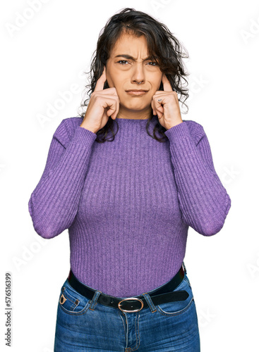 Young hispanic woman wearing casual clothes covering ears with fingers with annoyed expression for the noise of loud music. deaf concept.