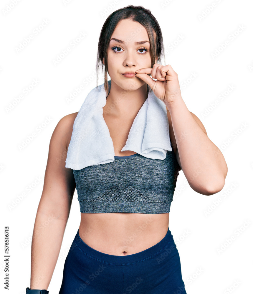 Young hispanic girl wearing sportswear and towel mouth and lips shut as zip with fingers. secret and silent, taboo talking Young hispanic girl wearing sportswear and towel mouth and lips shut as zip with fingers. secret and silent, taboo talking