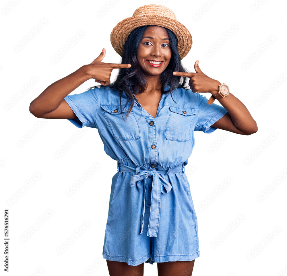 Young indian girl wearing summer hat smiling cheerful showing and pointing with fingers teeth and mouth. dental health concept. Young indian girl wearing summer hat smiling cheerful showing and pointing with fingers teeth and mouth. dental health concept.