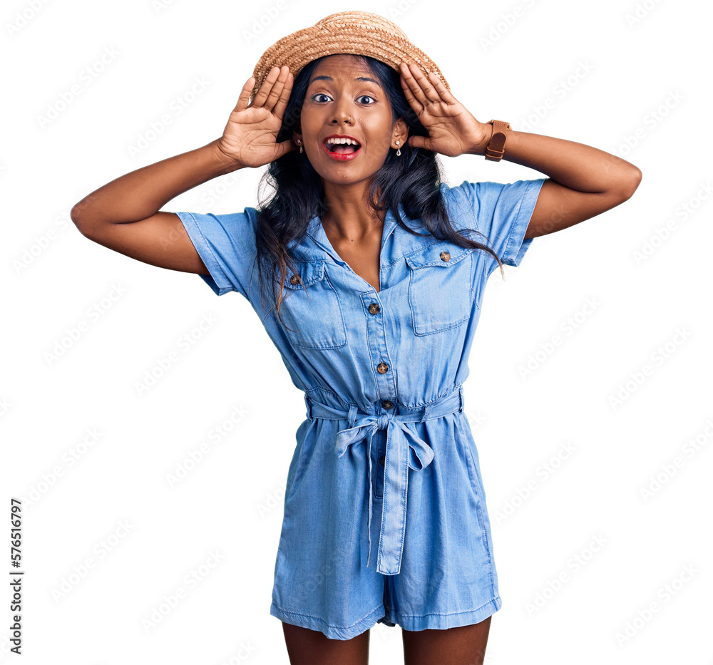 Young indian girl wearing summer hat smiling cheerful playing peek a boo with hands showing face. surprised and exited Young indian girl wearing summer hat smiling cheerful playing peek a boo with hands showing face. surprised and exited