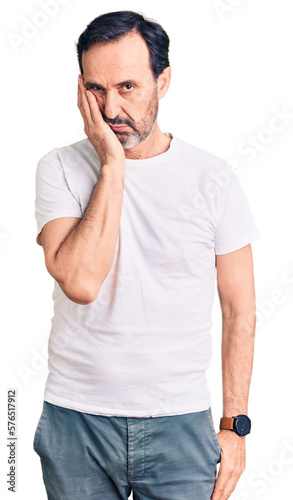 Middle age handsome man wearing casual t-shirt thinking looking tired and bored with depression problems with crossed arms.