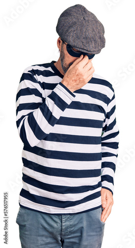 Middle age handsome man wearing burglar mask tired rubbing nose and eyes feeling fatigue and headache. stress and frustration concept.