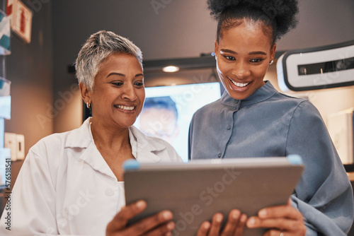 Tablet, optometry and optometrist talking to a patient about eye test results or consultation. Vision, technology and senior optician speaking to a black woman with a touchscreen at an optical clinic