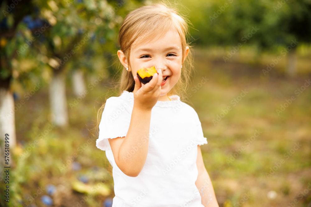 Sweet baby boy blond kid eats delicious plum and dessert cake on sunny summer day on natural background Sweet baby boy blond kid eats delicious plum and dessert cake on sunny summer day on natural background