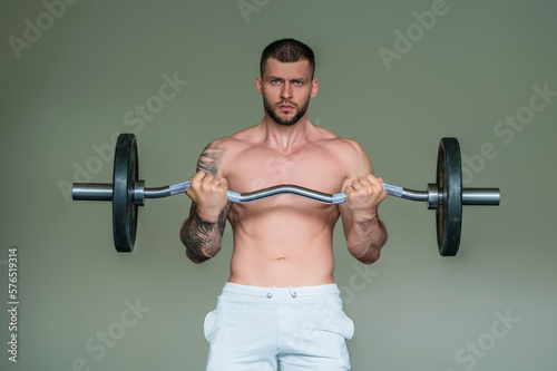 Sportsman muscular man workout in gym. Athletic man exercising with dumbbell. Fitness, sports concept, sport club, fitness center. Workout in gym. Sexy guy bodybuilder with perfect muscles body.
