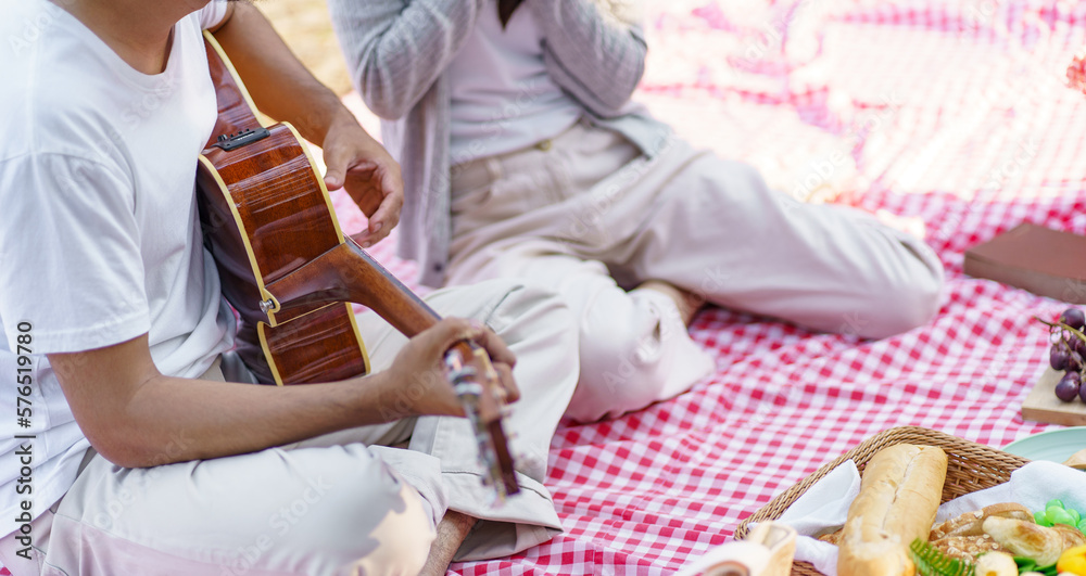 Fototapeta premium In love couple enjoying picnic time in park outdoors Picnic. happy couple relaxing together&nbsp;with picnic Basket