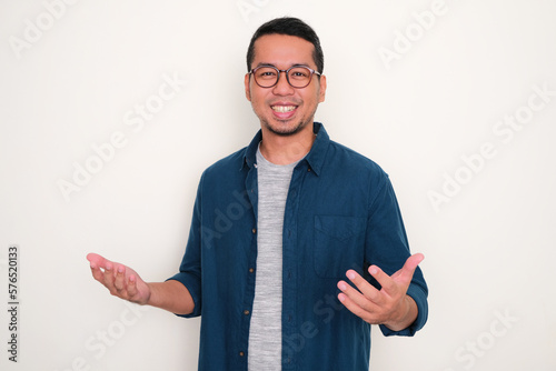 Adult Asian man smiling proud at the camera with arms open photo