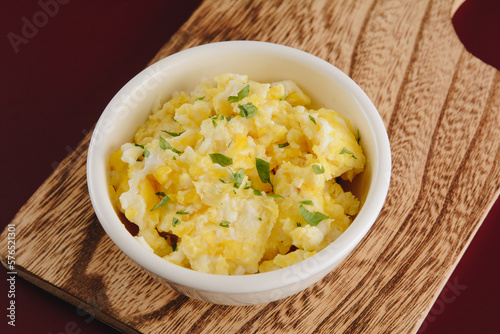 Scrambled eggs on bowl, wooden table