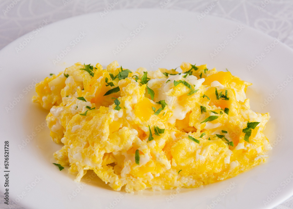 Scrambled eggs on plate, breakfast food, closeup, white background Scrambled eggs on plate, breakfast food, closeup, white background