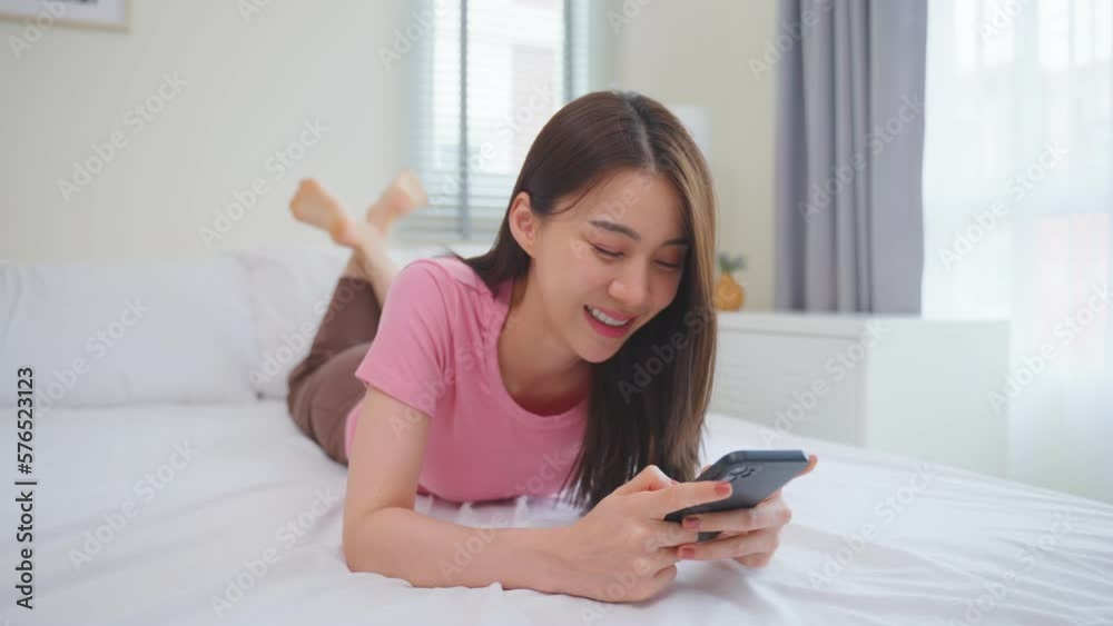 Asian attractive woman use mobile phone chat on bed at home in morning Asian attractive woman use mobile phone chat on bed at home in morning