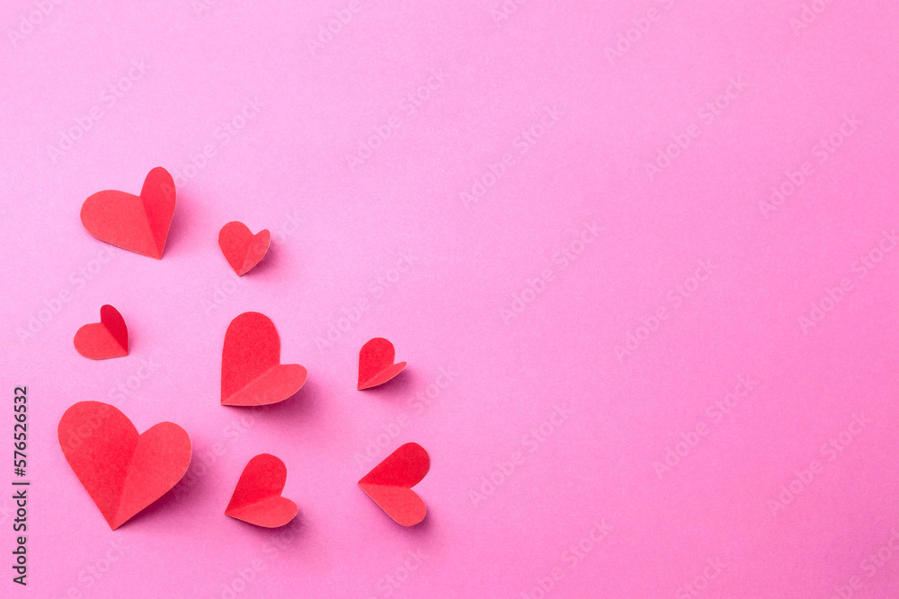 Red heart made of color paper cut on pink paper background. valentine day concept.