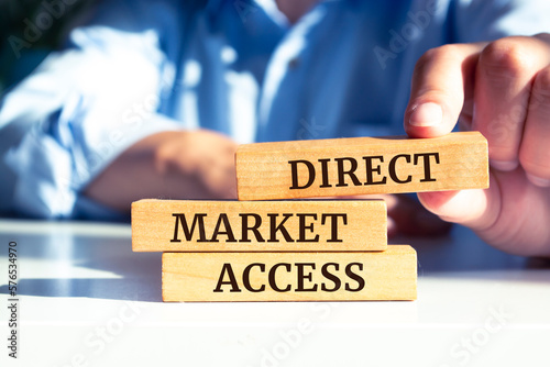 Close up on businessman holding a wooden block with "Direct market access" message