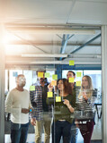Harnessing the mind power of a team. Shot of colleagues having a brainstorming session with sticky notes at work.