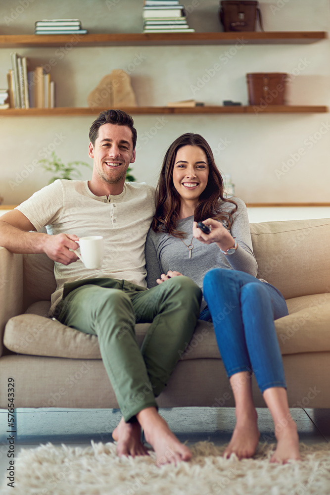 Movie date on the home front. Portrait of a happy young couple relaxing on the sofa and watching tv together. Movie date on the home front. Portrait of a happy young couple relaxing on the sofa and watching tv together.