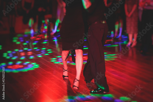 Couples dancing traditional latin argentinian dance milonga in the ballroom, tango salsa bachata kizomba lesson in the red and purple lights, festival, lesson class in dance school class academy photo