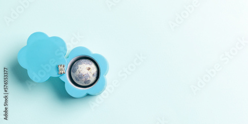 Creative Easter banner with jewelry box as flower with quail egg on light blue. Top view. Copy space