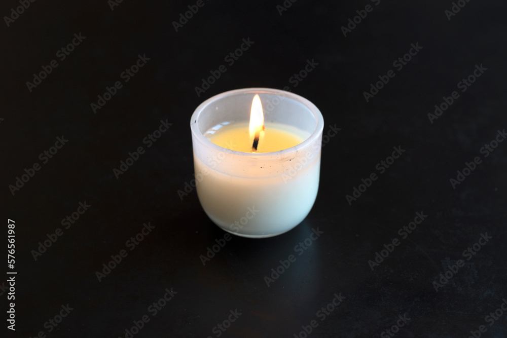 Burninng candle is on black table in the dark. Burninng candle is on black table in the dark.