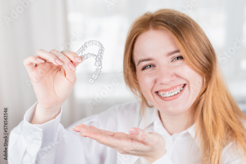 girl with a beautiful smile holding a transparent mouth guard photo