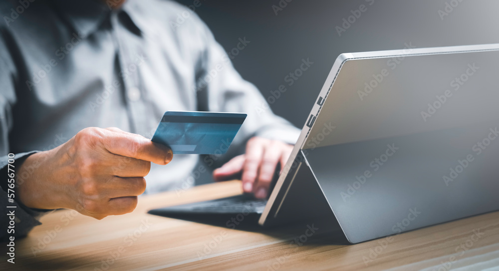 Business man hand holding credit card and using laptop, Entrepreneur working, Online shopping, e-commerce, internet banking, spending money, working from home, online shopping application concept.