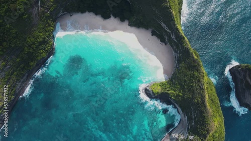 Nusa Penida kelingking beach bali t-rex dinosaur drone aerial top flying above view famous place in Asia indonesia colorful jurassic park green cliffs deep blue waves beautiful paradise environment photo