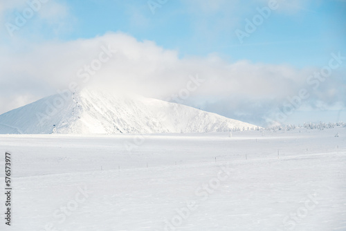 Alpine mountains landscape with white snow and blue sky. Sunset winter in nature. Frosty trees under warm sunlight. Krkonose Mountains National Park, Czech Republic ,Lucni bouda photo