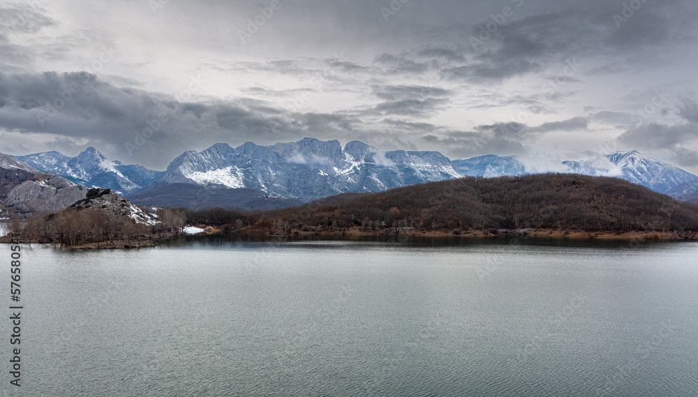 Landscape of the Porma Reservoir, forests and mountains in the background in winter. Province of Leon, Spain.