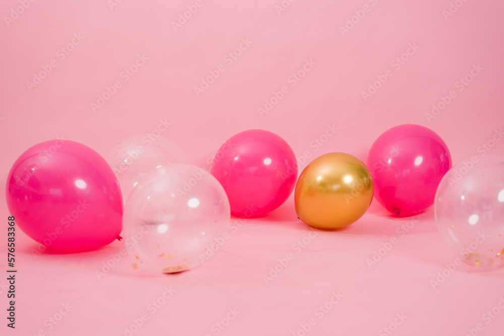Beautiful multicolored pink, gold and transparent with confetti or sequins lie on a pink background in a chaotic order. Concept of Valentine's day, birthday, mother's day Beautiful multicolored pink, gold and transparent with confetti or sequins lie on a pink background in a chaotic order. Concept of Valentine's day, birthday, mother's day