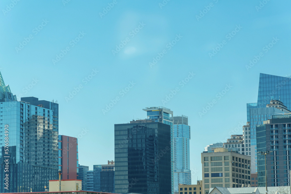 Downtown austin texas with office building and reflective glass with blue and hazy white sky in afternoon sun midday