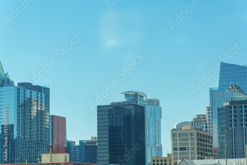Downtown austin texas with office building and reflective glass with blue and hazy white sky in afternoon sun midday