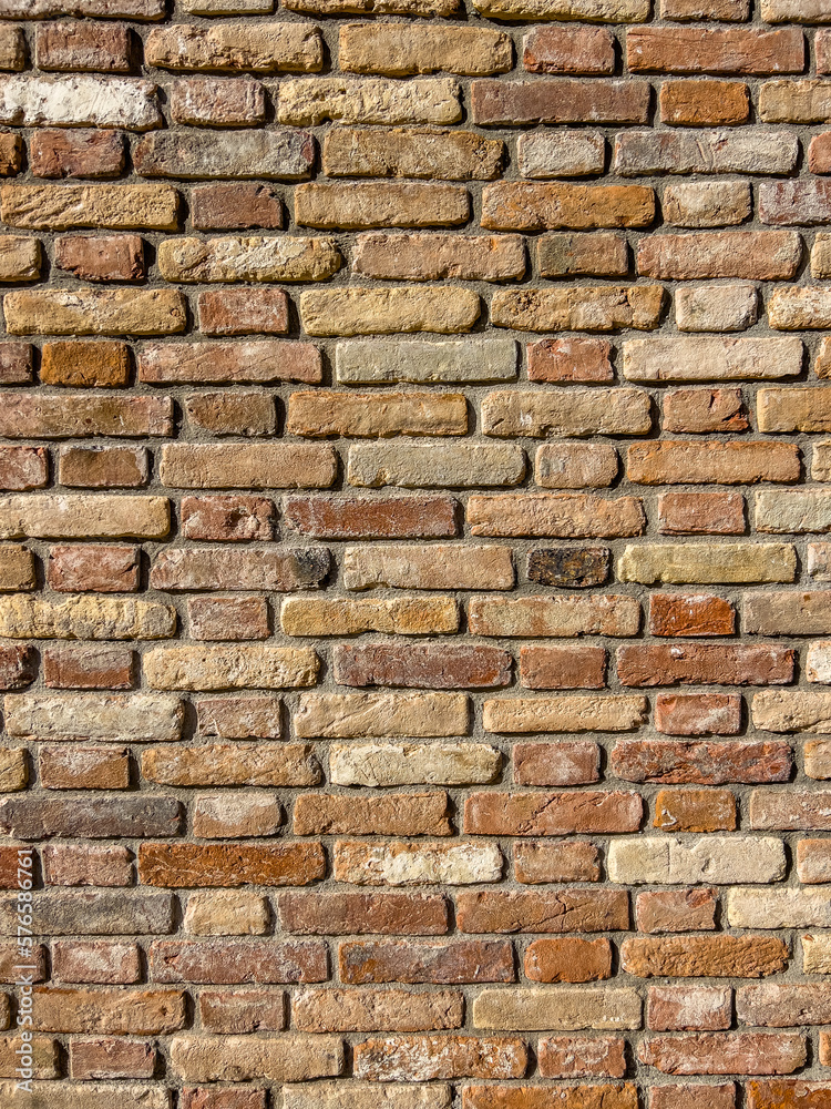 Naklejka premium Vertical traditional brick textured wall background in design loft style. Grunge reddish brown colored with copy space. Blank poster or wallpaper surface template. Partly damaged pattern.