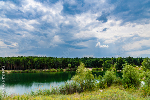View on a lake in the abandoned sand quarry and dramatic sky