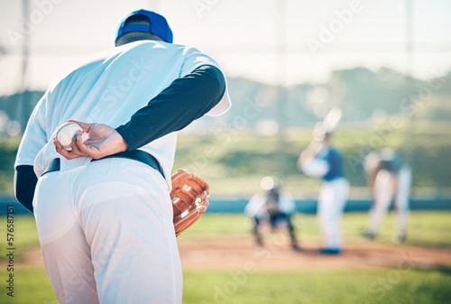 Man, baseball and pitcher ready to throw ball for game, match or victory shot on grass field at pitch. Male sports player with hand behind back with mitt in preparation for sport pitching outdoors