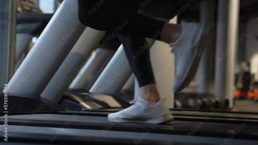 Athlete running on fitness treadmill in gym. Treadmill workout of athlete. Fitness gym equipment.