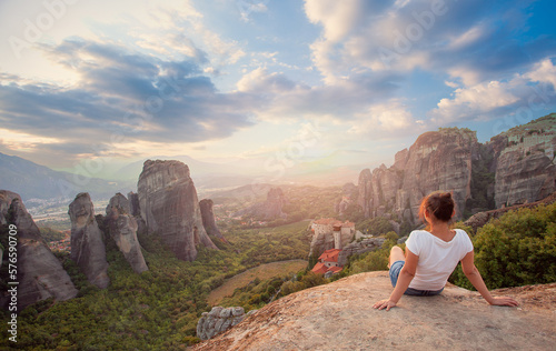 Woman overlooking the rockformations of meteora at sunset photo