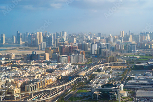 Aerial view of an airplane wing flying over Dubai Downtown skyline, highway roads or street in United Arab Emirates or UAE. Financial district and business area in urban city. Skyscraper buildings