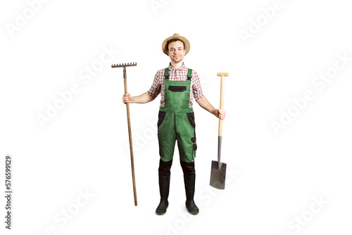 Smiling gardener holding a rake and a spade