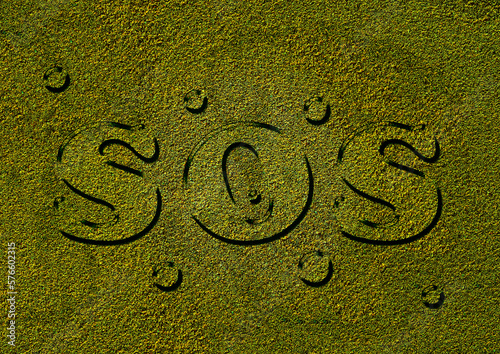 SOS written on a yellowed grass texture, water drops. Symbolic representation. Climate change and lack of water