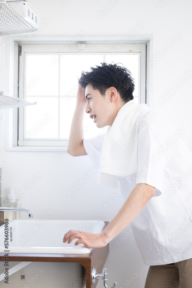 髪の毛が気になる朝の男性の洗面台での様子 髪の毛が気になる朝の男性の洗面台での様子