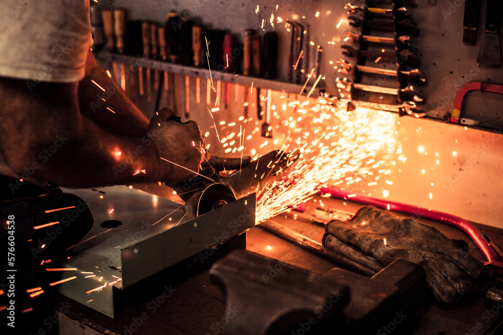 Mechanic cutting a custom made steel plate with sparks Mechanic cutting a custom made steel plate with sparks