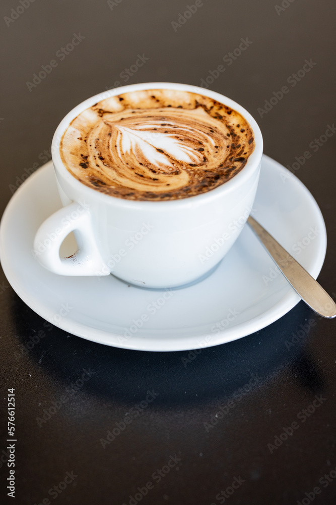 Obraz premium Cappuccino con un disegno di un cuore sulla schiuma servito in un bar per colazione