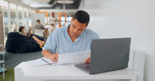 Office documents, laptop and man writing feedback review of business savings, budget or finance portfolio. Accounting, administration and startup accountant working on financial research paperwork